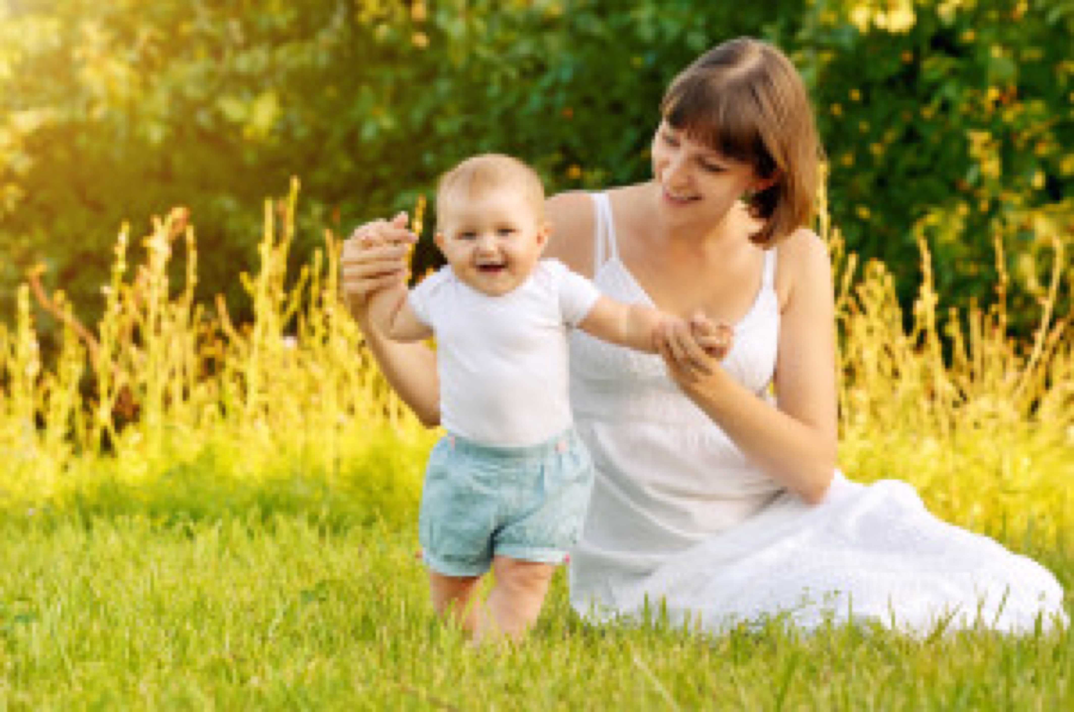 picture of mother playing with adorable baby on green grass in park baby looking at camera
