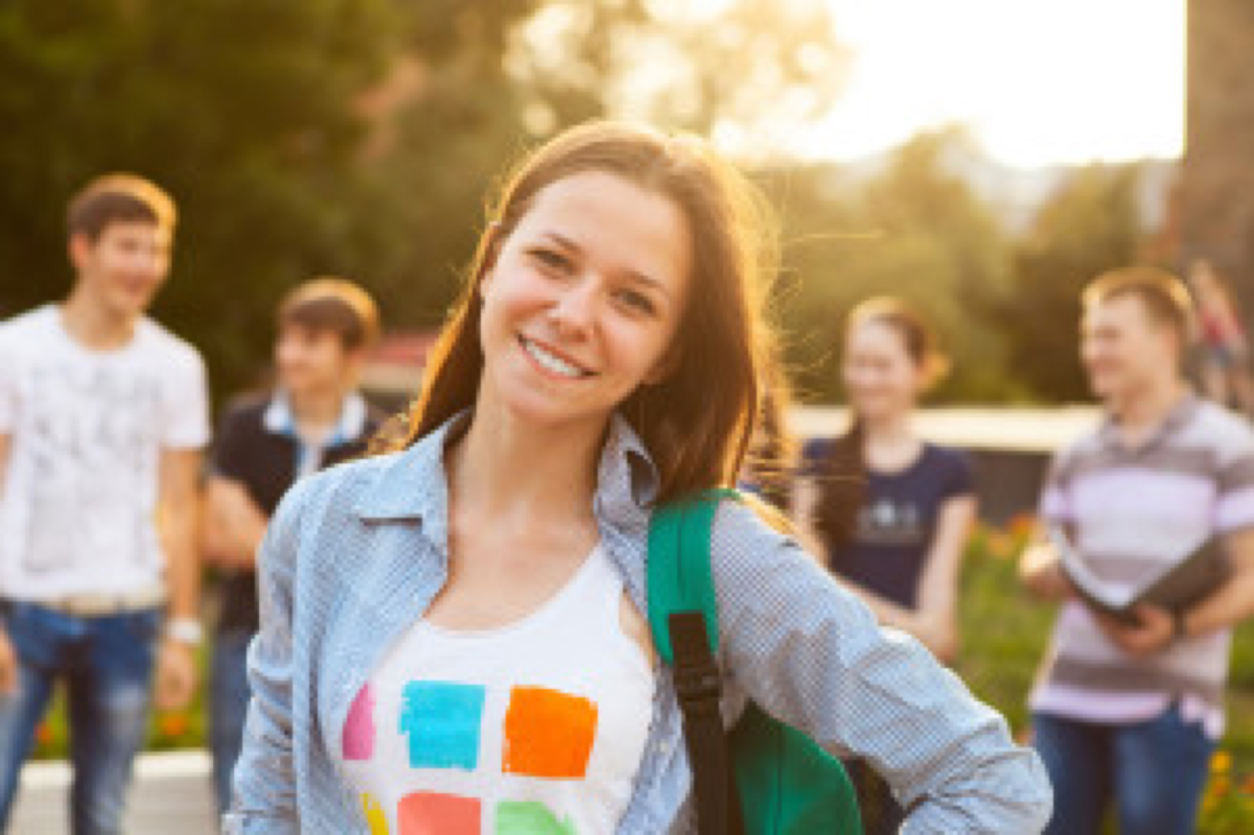 Female smiling student outdoors in the evening with friends