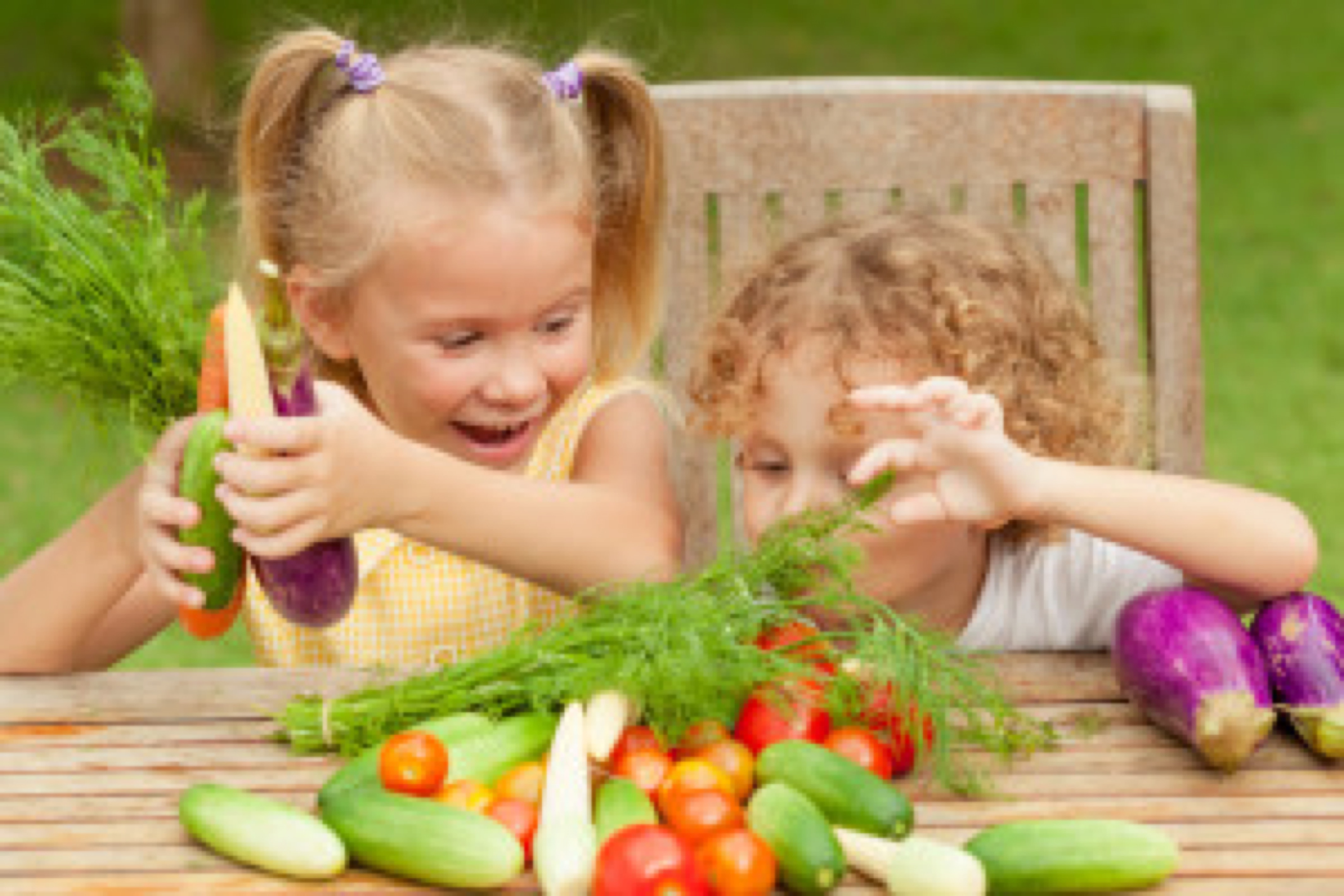 Two happy little kids with vegetables . Concept of healthy food.